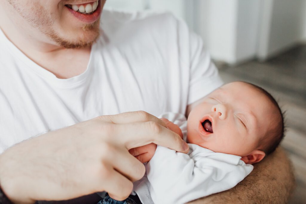 Neugeborenes im Arm vom Vater