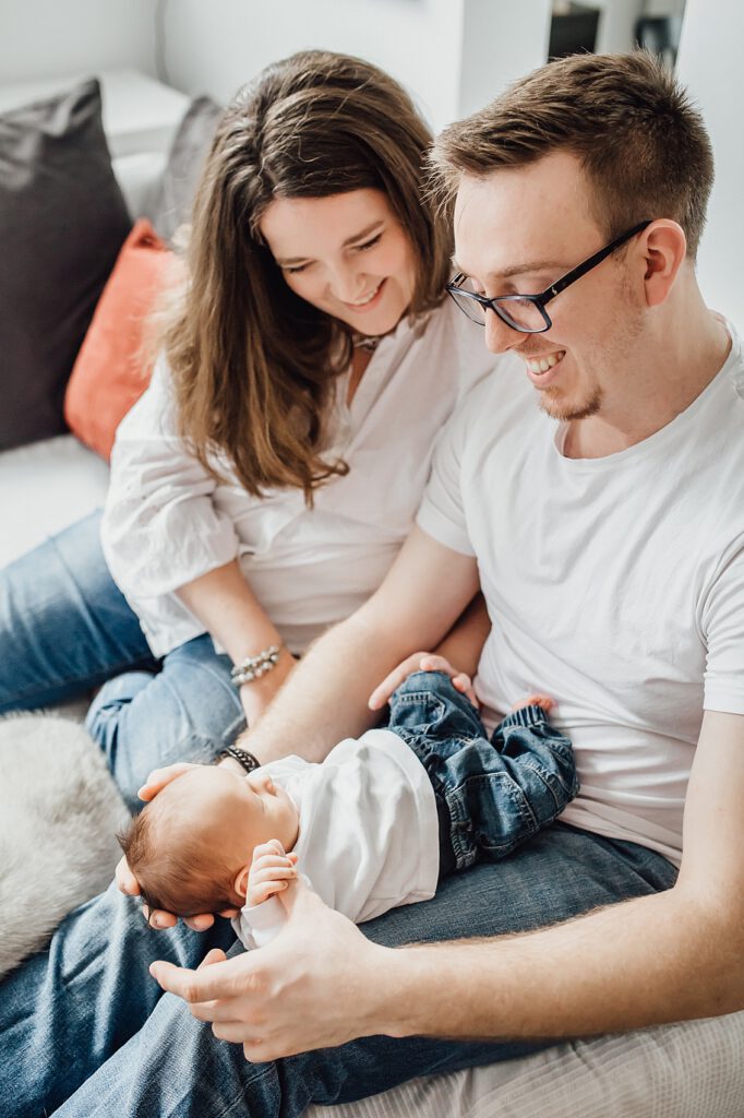 Mama und Papa halten ihr Baby im Arm