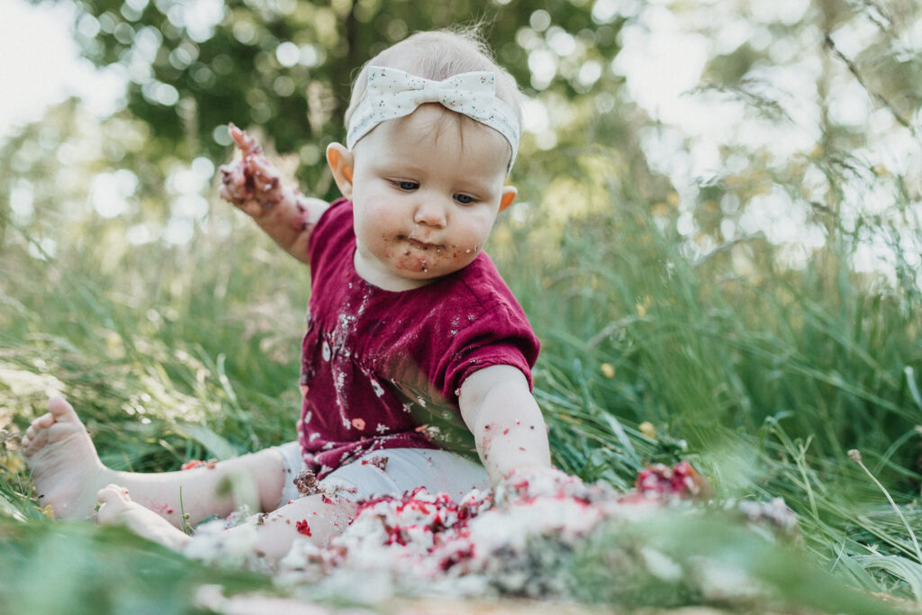 Baby greift nach Kuchenresten bei der Cake Smash Session