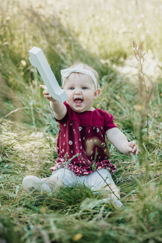 Baby auf der Wiese mit ihrer Geburtstagszahl 