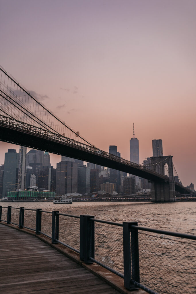 Brooklyn Bridge im Abendlicht mit Holzpromenade im Vordergrund